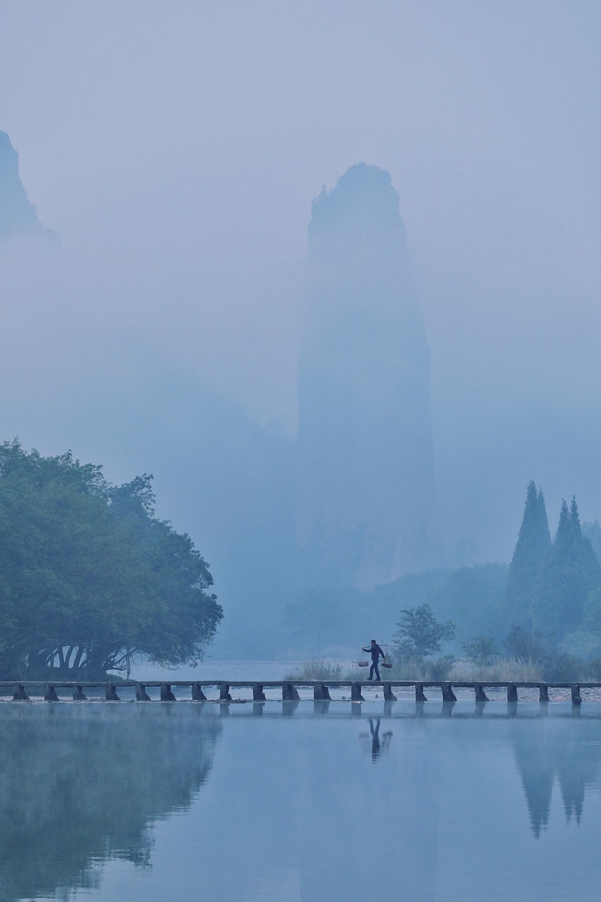 Original photo of a misty valley with a stone peak and a low wooden bridge over still water