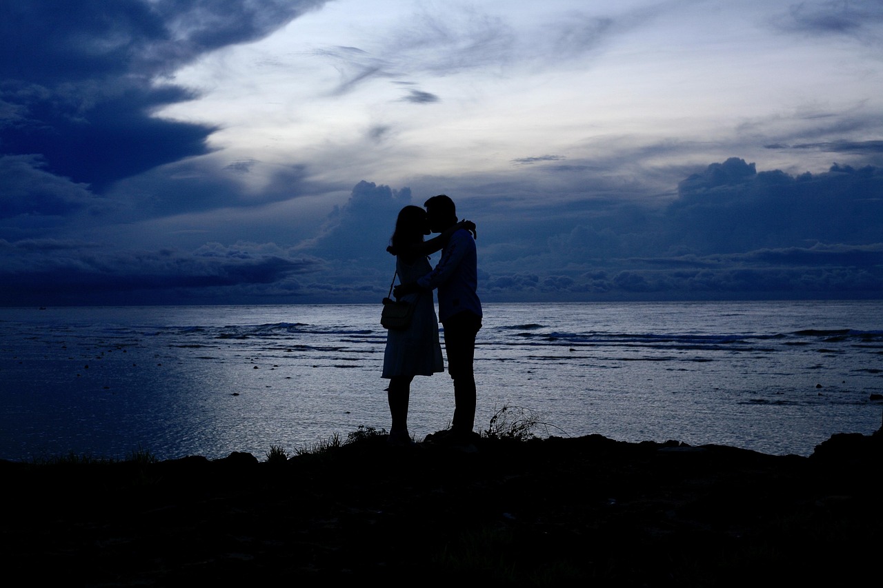Original phone photo of a couple embracing on the beach at dusk
