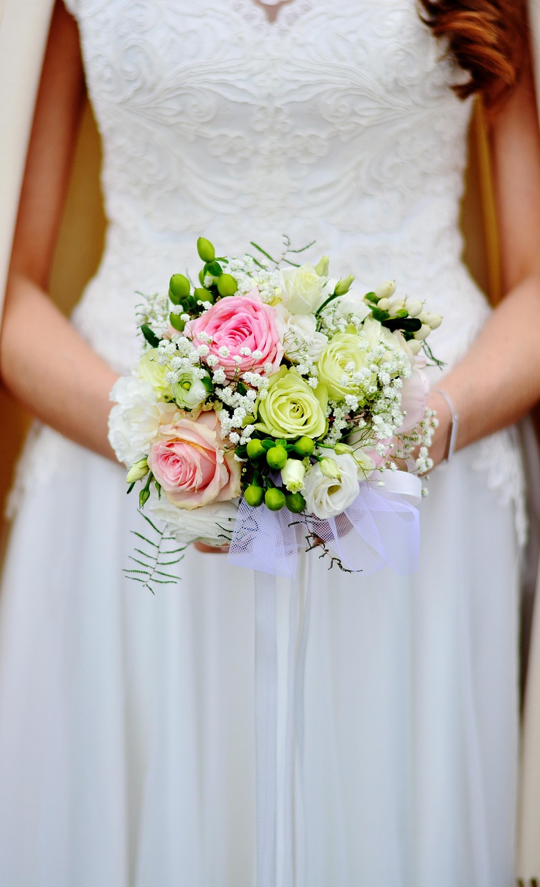 Photo of a bride holding a soft pink and white bridal bouquet